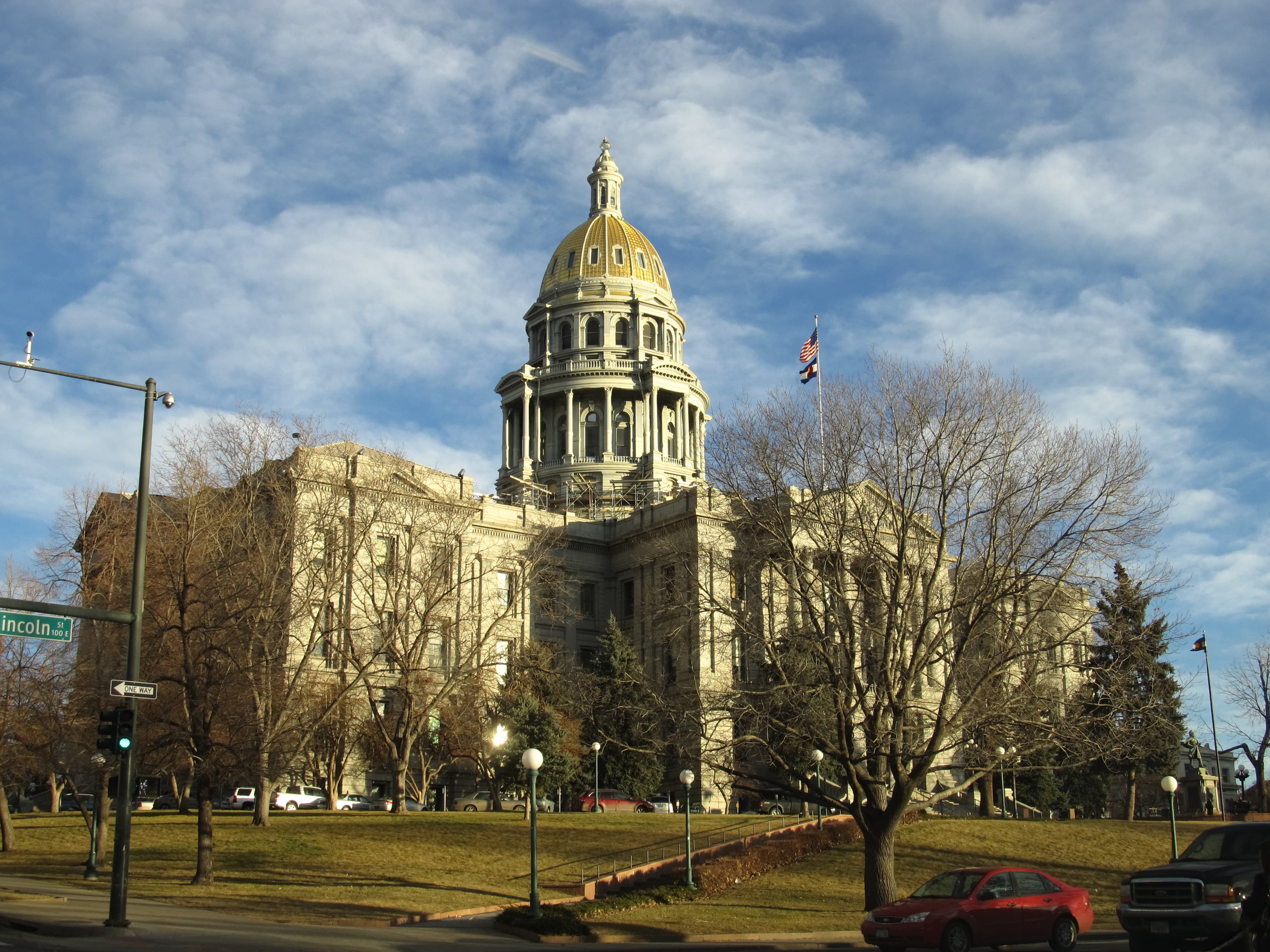 The Colorado State Capitol with its gold-leaf dome at the western edge of Capitol Hill, under a partly cloudy Denver sky