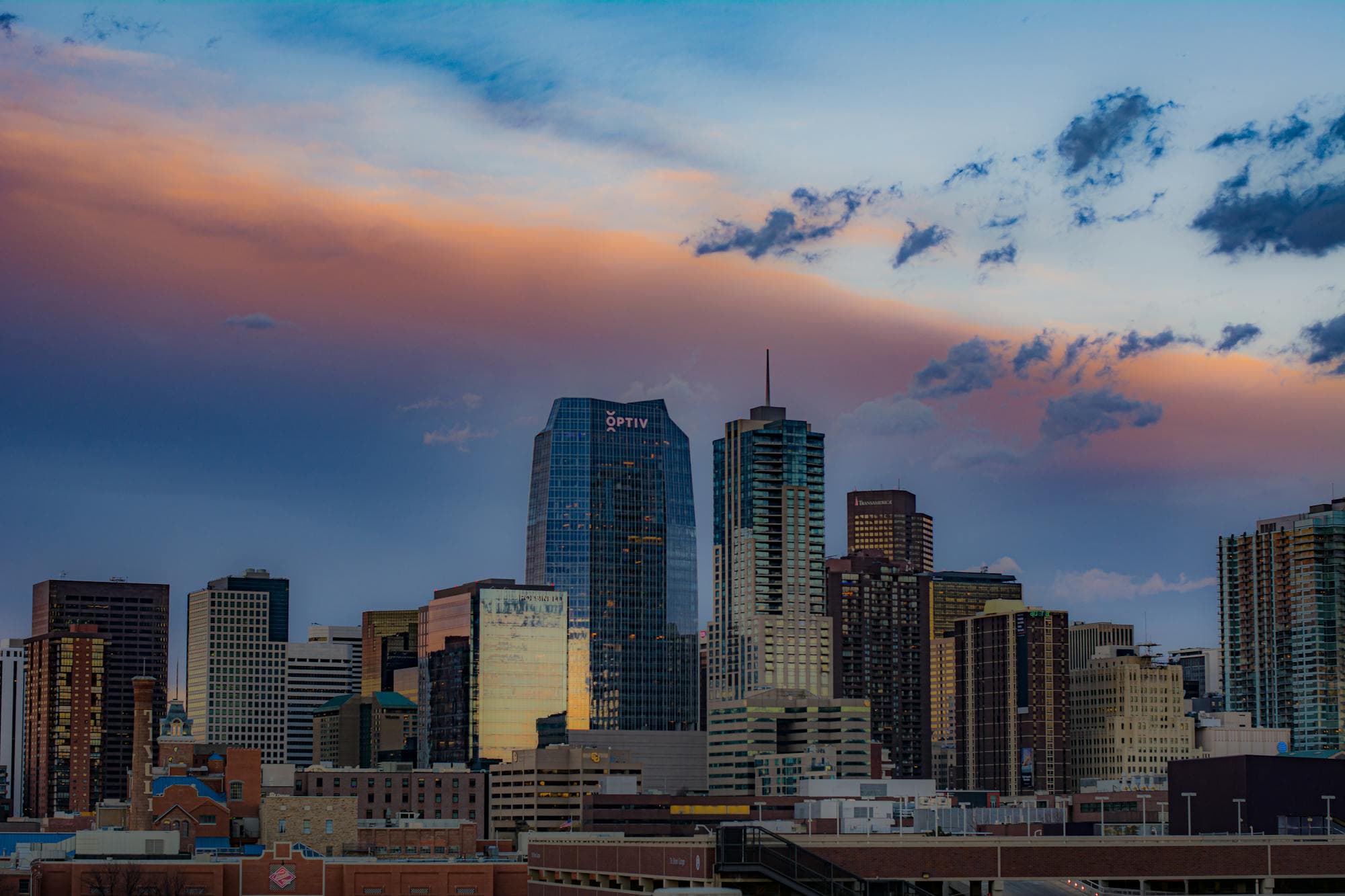 Downtown Denver's skyline at dusk under a pink and purple sky